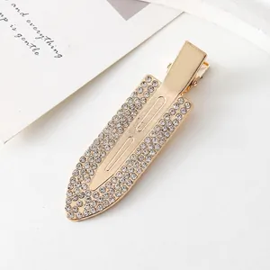 Vue détaillée d'une barrette en alliage doré ornée de strass brillants et élégants
