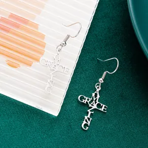 Detail view of silver titanium steel earrings with Amazing Grace hollow cross design