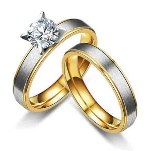 Detail view of two-tone stainless steel rings showing matte texture and prong-set stone.