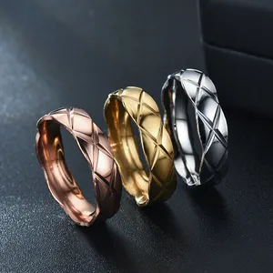 Detailed macro shot of three quilted stainless steel rings in gold, rose gold and silver