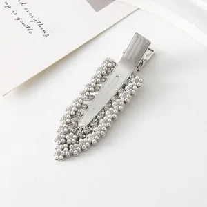 Vue détaillée d'une barrette argentée avec perles blanches et strass brillants