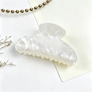 Detailed view of the elegant pearlescent white marble texture on this hair claw clip