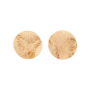 Vue détaillée des boucles d'oreilles dorées vintage avec disque texturé