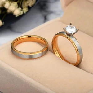 Macro detail view of two-tone stainless steel rings with a large solitaire zircon