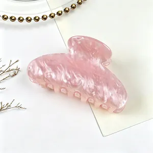 Macro detail of pink water ripple acrylic hair claw clip with pearlescent texture