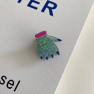 Close-up detail of glittery green monster hand shaped Halloween acrylic hair claw clip