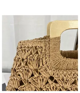 Close-up of vintage straw woven bag with natural wooden handle and intricate texture