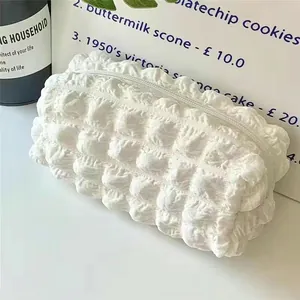 Close-up of cream colored puff pencil case with bubble texture and zipper closure