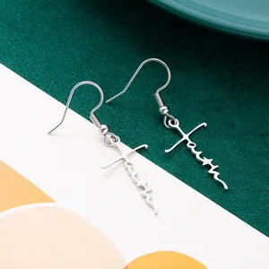 Close-up of minimalist stainless steel faith cross dangle earrings in silver color
