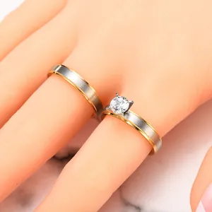 Macro view of two-tone matte stainless steel rings with four-claw zircon