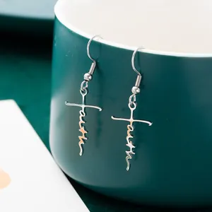 Detail shot of silver stainless steel cross earrings with 'Faith' script design