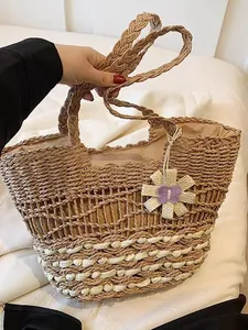 Grote stro geweven strandtas met bloemenbedel voor de zomervakantie en het strand