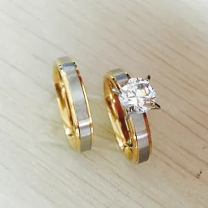 Detail of two-tone stainless steel couple rings with a matte finish and a sparkling cubic zirconia stone.