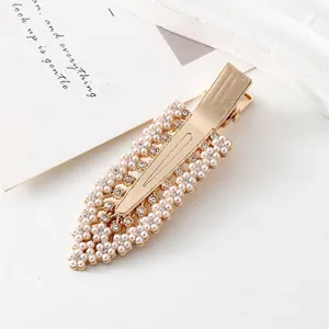 Détail de la pince à cheveux fleur dorée avec perles et strass brillants