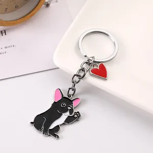 Detailed macro view of cute waving black French Bulldog keychain with red heart charm