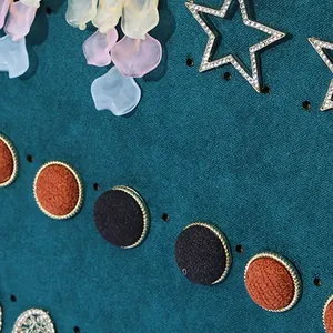 Dark green velvet jewelry display board with holes for organizing earrings and studs