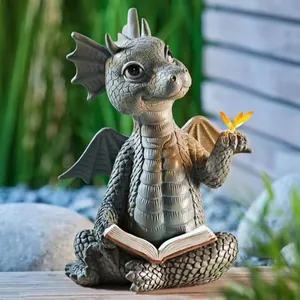 Whimsical resin dragon garden statue reading a book featuring a glowing butterfly accent