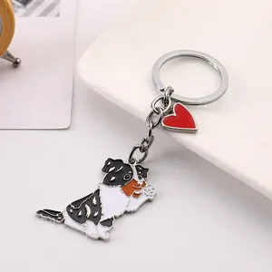 Close-up of a cute waving Australian Shepherd dog keychain with a red heart charm.