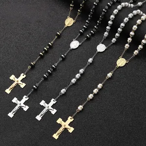 Detailed view of stainless steel rosary necklaces with cross pendants and black/white beads.