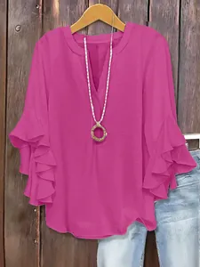 Detail of pink V-neck blouse with elegant ruffled sleeves and lightweight fabric