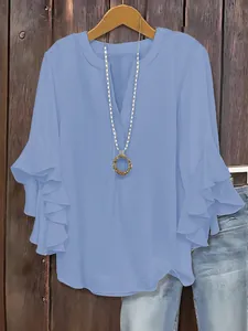 Elegant sky blue V-neck blouse with tiered ruffle sleeves on a hanger