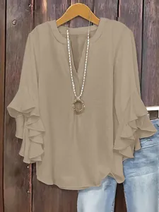 Close-up detail of a solid color loose V-neck blouse with stylish ruffle 3/4 sleeves.