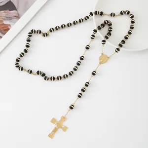 Detailed view of stainless steel rosary necklace with black beads and gold cross