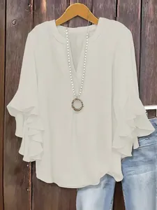Detail view of a white V-neck blouse with elegant ruffle 3/4 sleeves for women
