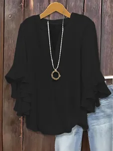 Close-up of black loose V-neck blouse with tiered ruffle 3/4 sleeves