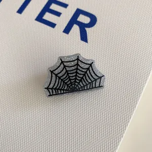 Macro view of silver glitter spider web acrylic hair claw clip for Halloween.