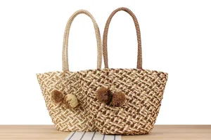 Detailed view of two woven paper rope tote bags with pom-pom tassels for summer vacation.