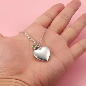 Elegant silver stainless steel heart locket necklace with a green birthstone charm detail