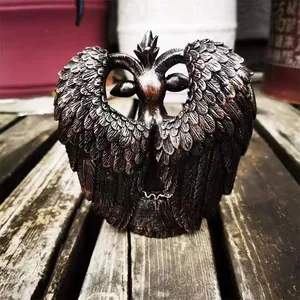 Detailed macro shot of a winged Black Goat Satan sculpture on a wooden surface
