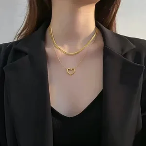 Dettaglio di un'elegante collana a doppio strato in oro con cuore e catena a serpente