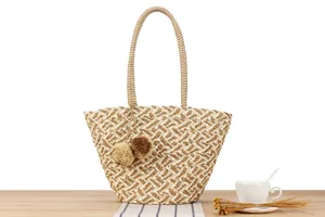 Summer paper rope woven tote bag with decorative pom poms and large capacity design.