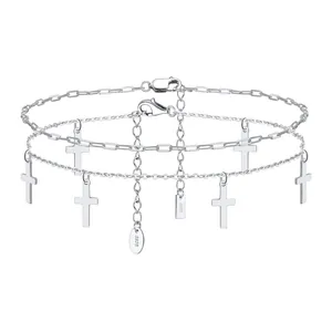 Macro view of layered S925 sterling silver anklet set featuring polished cross charms
