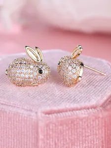 Gros plan de boucles d'oreilles lapin plaquées or pavées de cristaux étincelants.