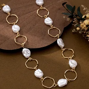 Close-up of a elegant baroque imitation pearl and golden ring link necklace detail