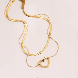 Dettaglio dell'elegante collana d'oro a due strati con ciondolo a forma di cuore cavo.