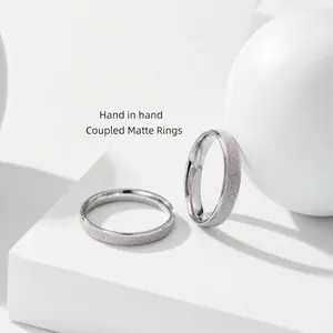 Primo piano di anelli in argento sterling S925 con trama satinata per coppie in dettaglio.