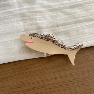 Detailed close-up of a shark-shaped cellulose acetate hair claw clip with spots