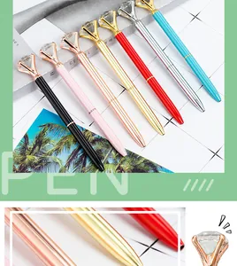 Detailed view of elegant metal ballpoint pens with large sparkling crystal diamond toppers