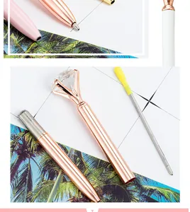 Close-up of elegant rose gold metal ballpoint pen with large crystal diamond top