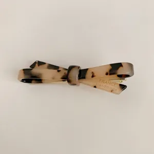 Close-up view of an elegant tortoiseshell acetate bow hair clip with French handmade engraving