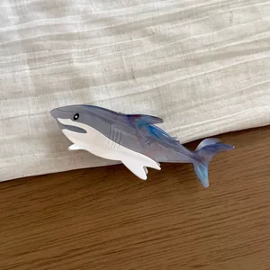 Large shark-shaped acetate hair claw clip featuring a blue marble and white finish.