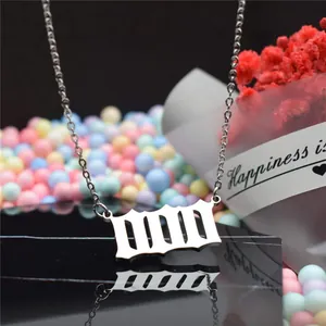 Detailed close-up of a silver Gothic angel number necklace on a black reflective base