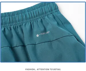 Close-up detail of teal men's athletic shorts featuring reflective print and elastic waistband