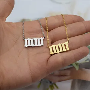 Detailed macro shot of gold and silver angel number pendants held in a person's hand