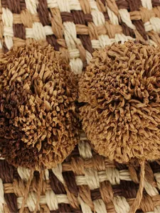 Close-up detail of handcrafted paper rope decorative balls on summer straw handbag