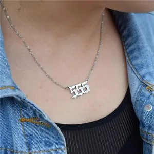 Detail view of a silver stainless steel 555 angel number necklace worn by a model.